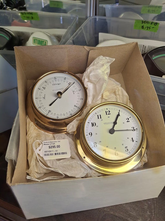 brass clock and brass barometer in a box with tissue paper
