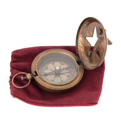 Brass compass on a red cloth with a white background