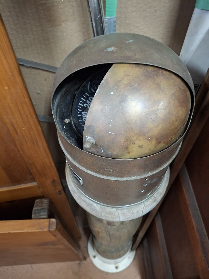 Vintage-style compass on a stand with a wooden background