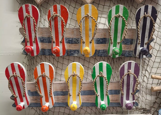 Colorful flip-flop decorations on a wall with decorative items below.