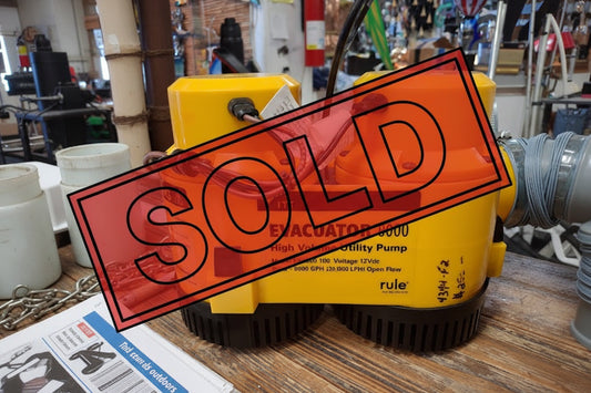 Yellow EVACUATOR 8000 high volume utility pump on a wooden surface with a store background.
