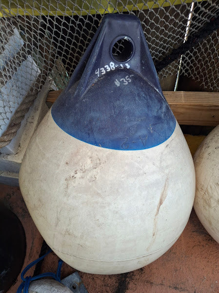 White buoy with blue top on a metal surface