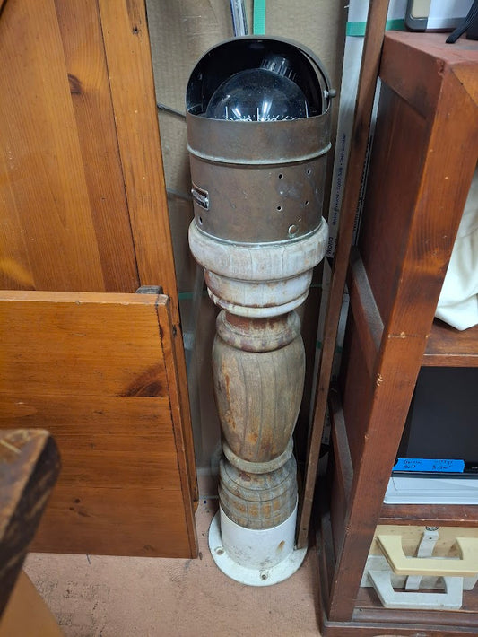 Decorative wood pedestal holding a brass binnacle