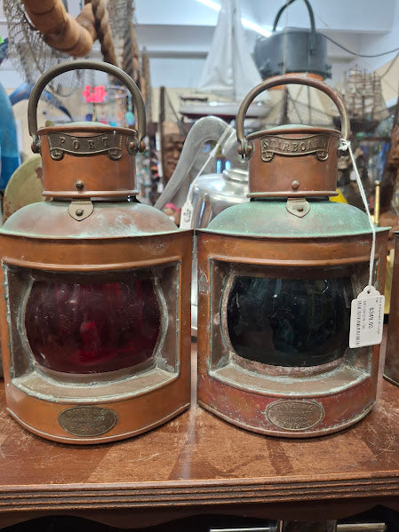 Two vintage-style lanterns on a wooden surface with a blurred background.