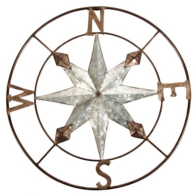 Decorative metal compass wall art on a white background