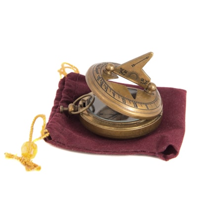 Brass compass on a red cloth with a white background