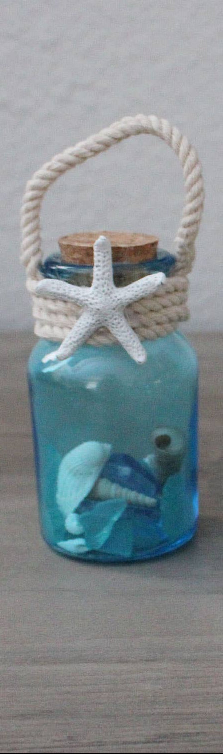 Decorative bottle with starfish and seashell on a wooden surface