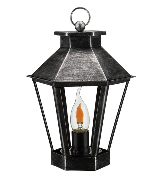Black lantern with a lit candle inside on a white background