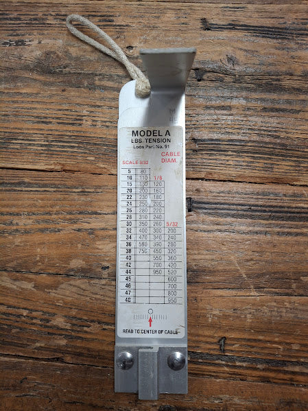Metal tension gauge on a wooden surface